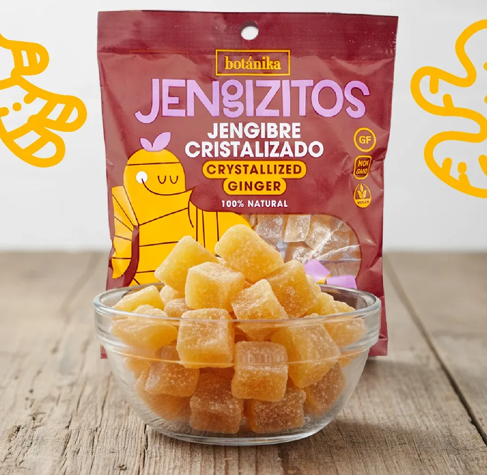 Bolsa de jengibre cristalizado junto a un bol con cubitos azucarados